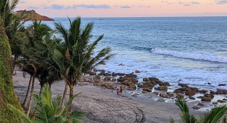 Pantai Pecaron di Desa Srati, Kebumen, menawarkan hamparan pasir gelap, tebing batu, dan deretan pohon kelapa dengan suasana pesisir yang alami.